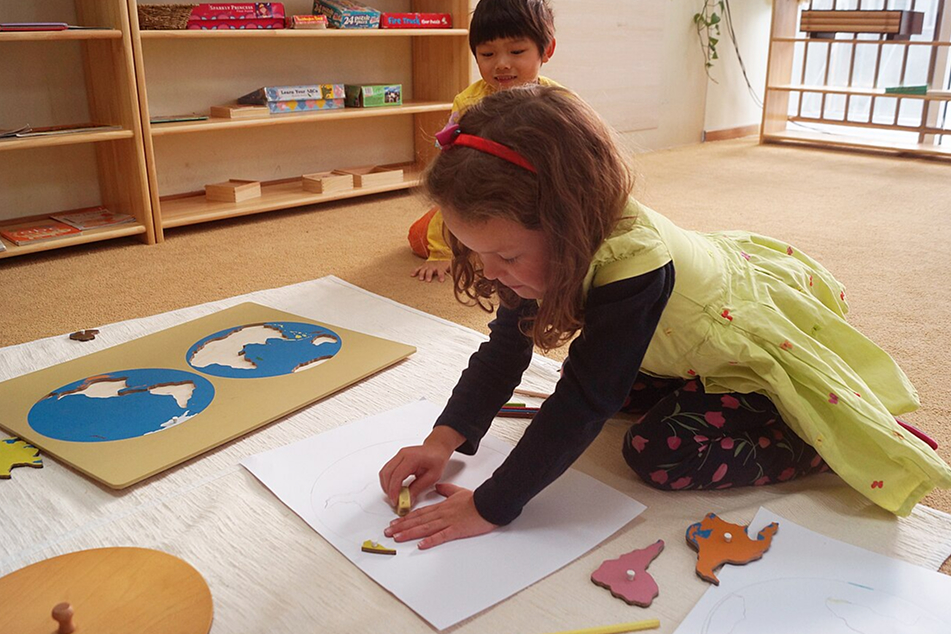 A girl drawing a map on the floor